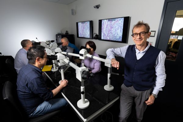 Man standing in front of large microscope